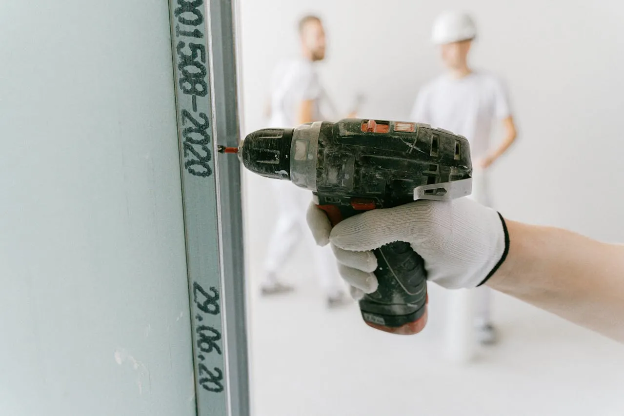 Worker installing drywall in an office space showcasing professional techniques and tools